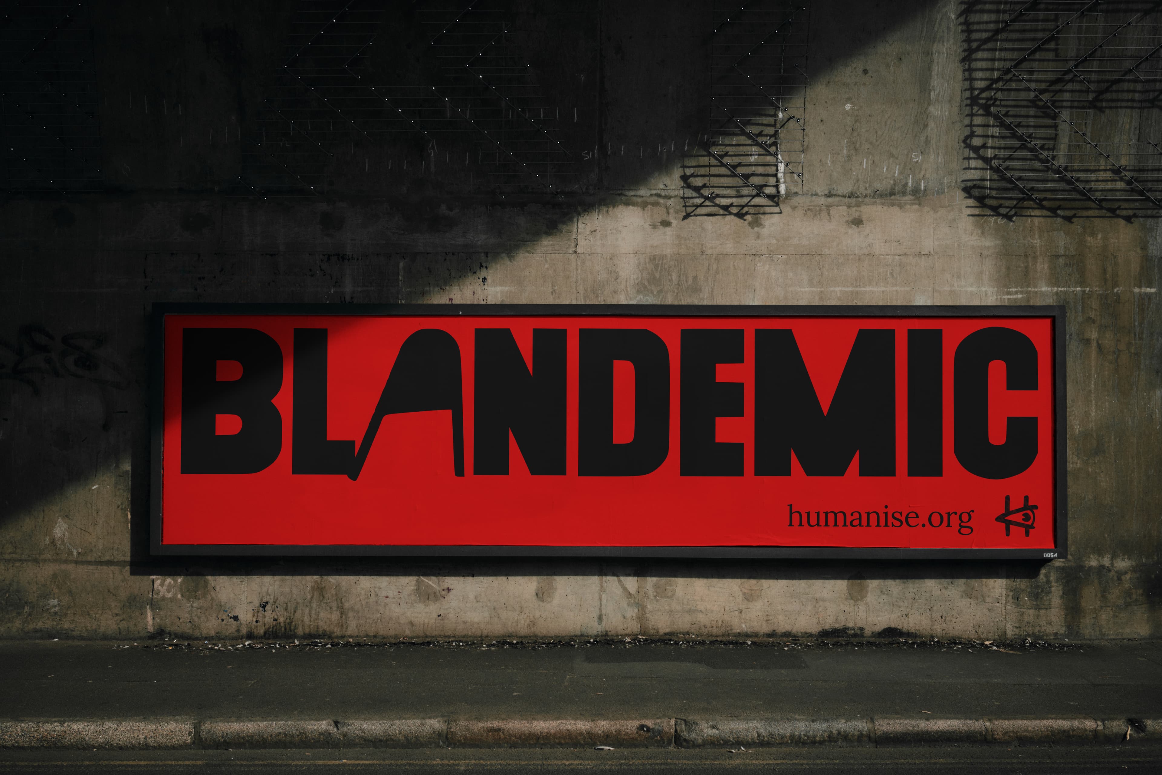 Image of a red billboard against concrete with the text 'Blandemic' in the 'Humanise' typeface