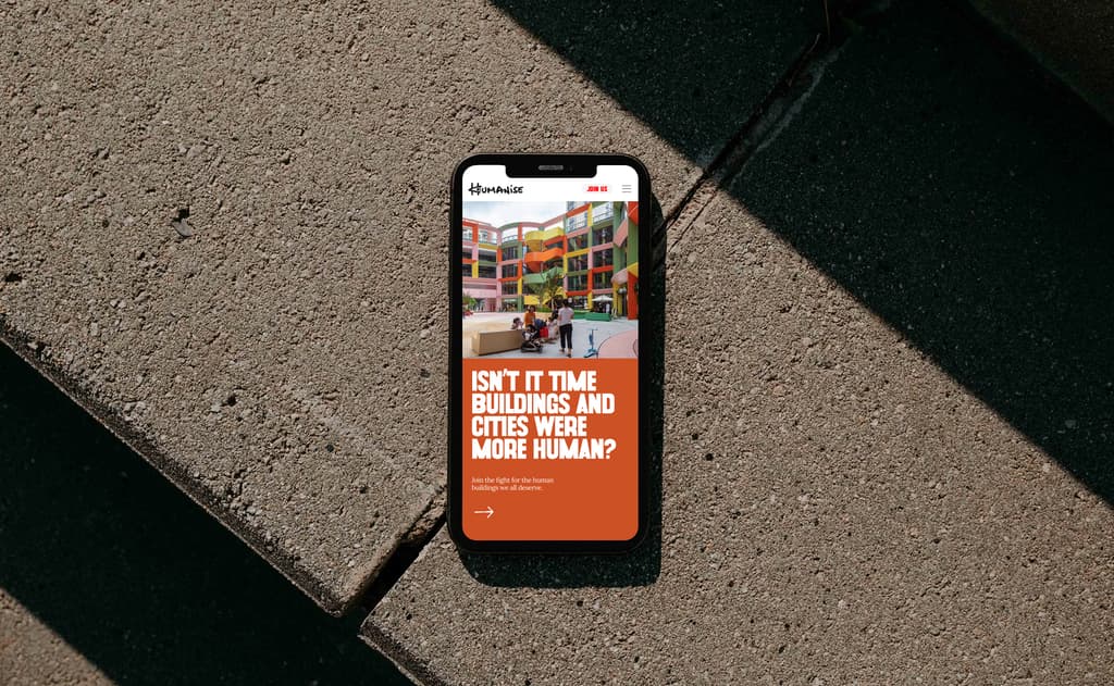 Mobile phone on concrete with Humanise website on screen